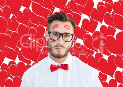 Composite image of geeky hipster with kisses on his face