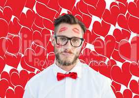 Composite image of geeky hipster with kisses on his face