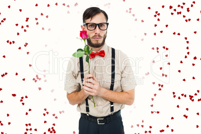 Composite image of geeky hipster offering a rose