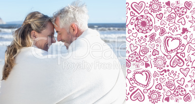 Composite image of couple sitting on the beach under blanket smi