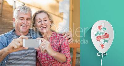 Composite image of happy mature couple taking a selfie together