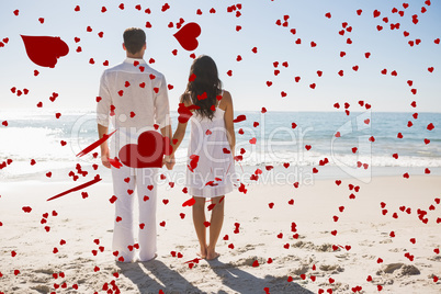 Composite image of attractive couple holding hands and watching