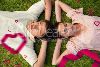 Composite image of two friends lying head to head with both hand
