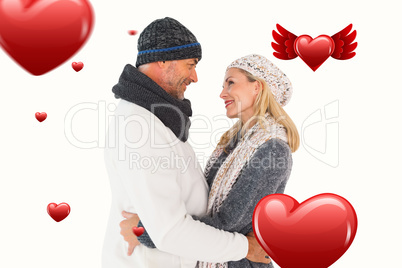 Composite image of happy couple in winter fashion embracing