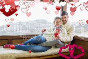 Composite image of couple in winter wear with coffee cups agains