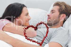 Composite image of couple awaking and looking at each other