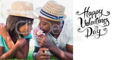 Composite image of happy couple lying in garden together smellin