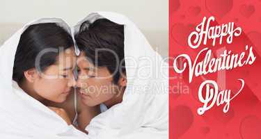 Composite image of happy couple lying on bed together under the