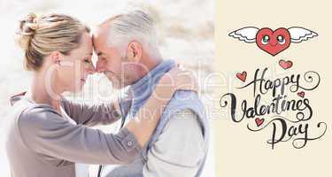 Composite image of happy hugging couple on the beach looking at