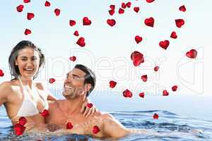 Composite image of couple enjoying time together in the pool