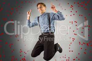 Composite image of geeky hipster jumping and pointing