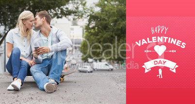 Composite image of cute young couple sitting on skateboard kissi