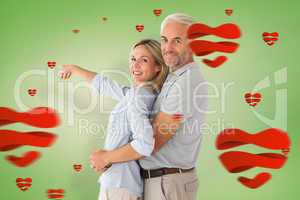 Composite image of happy couple smiling at camera and pointing