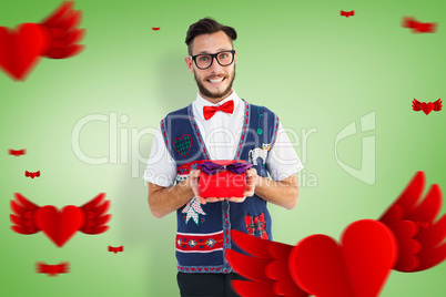 Composite image of geeky hipster offering christmas gift