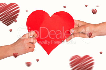 Composite image of hands holding red heart