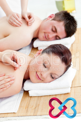 Composite image of relaxed couple receiving a back massage Composite image of relaxed couple receiving a back massage