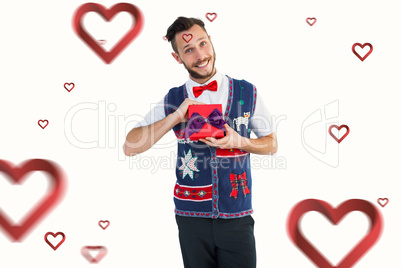 Composite image of geeky hipster offering christmas gift