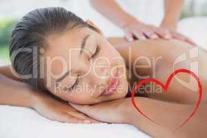 Composite image of beautiful brunette enjoying a massage