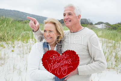 Composite image of cheerful romantic senior couple at beach