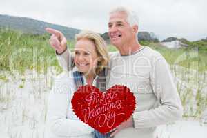 Composite image of cheerful romantic senior couple at beach