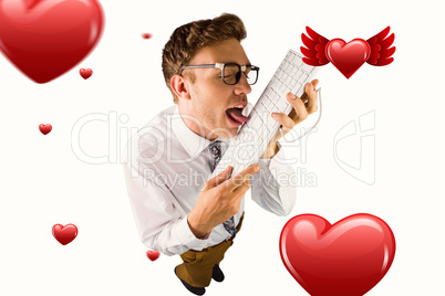 Composite image of geeky businessman licking his keyboard