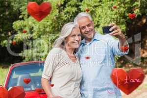 Composite image of cheerful mature couple taking pictures of the