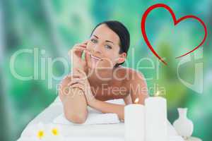 Composite image of beautiful brunette relaxing on massage table