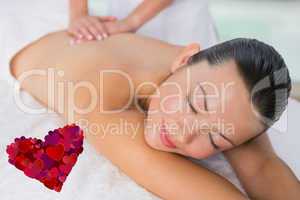 Composite image of content brunette enjoying a back massage