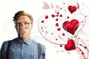 Composite image of geeky hipster covered in kisses