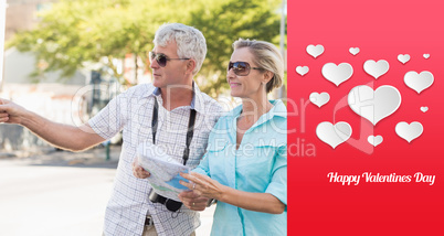 Composite image of happy tourist couple using map in the city