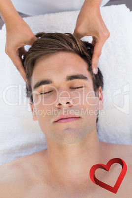 Composite image of man receiving head massage at spa center