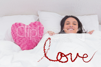 Composite image of woman lying in bed next to a fluffy heart pil