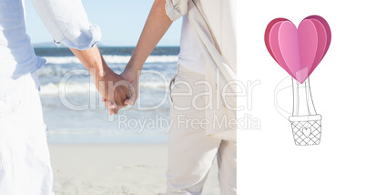 Composite image of couple on the beach looking out to sea holdin