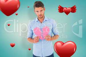 Composite image of sad man holding a broken heart