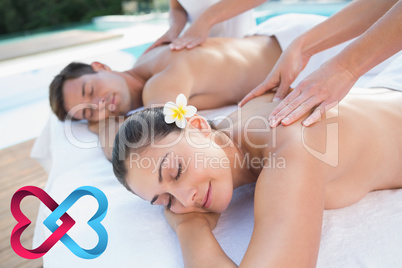 Composite image of attractive couple enjoying couples massage po