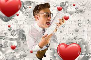 Composite image of geeky businessman licking his keyboard