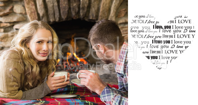 Composite image of couple with tea cups in front of lit fireplac