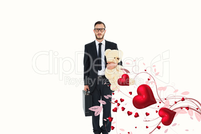 Composite image of geeky businessman holding briefcase and teddy