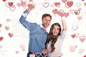 Composite image of happy young couple cheering