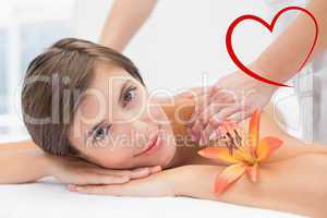 Composite image of attractive woman receiving shoulder massage a