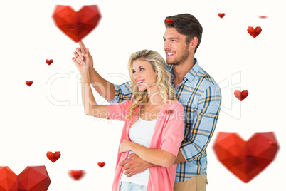 Composite image of attractive young couple embracing and pointin