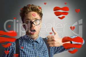 Composite image of geeky hipster covered in kisses