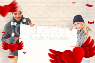 Composite image of attractive couple in winter fashion showing p