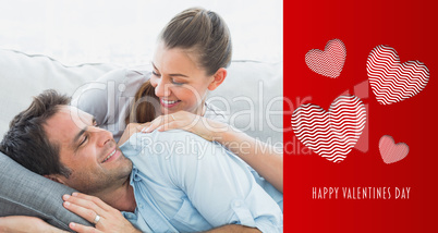 Composite image of cheerful couple relaxing on their sofa smilin