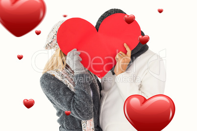 Composite image of couple in winter fashion posing with heart sh