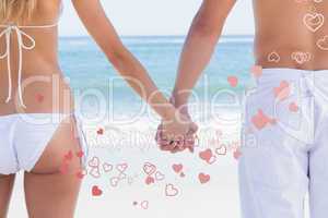 Composite image of young couple in swimwear holding hands