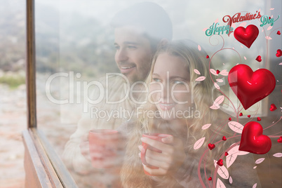 Composite image of thoughtful content couple with cups looking t