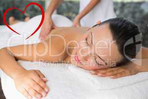 Composite image of content brunette enjoying a back massage