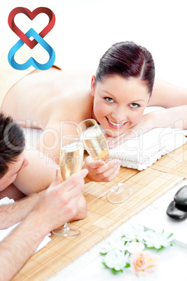 Composite image of young couple lying on a massage table and dri