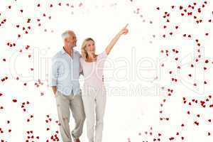 Composite image of smiling couple walking and pointing